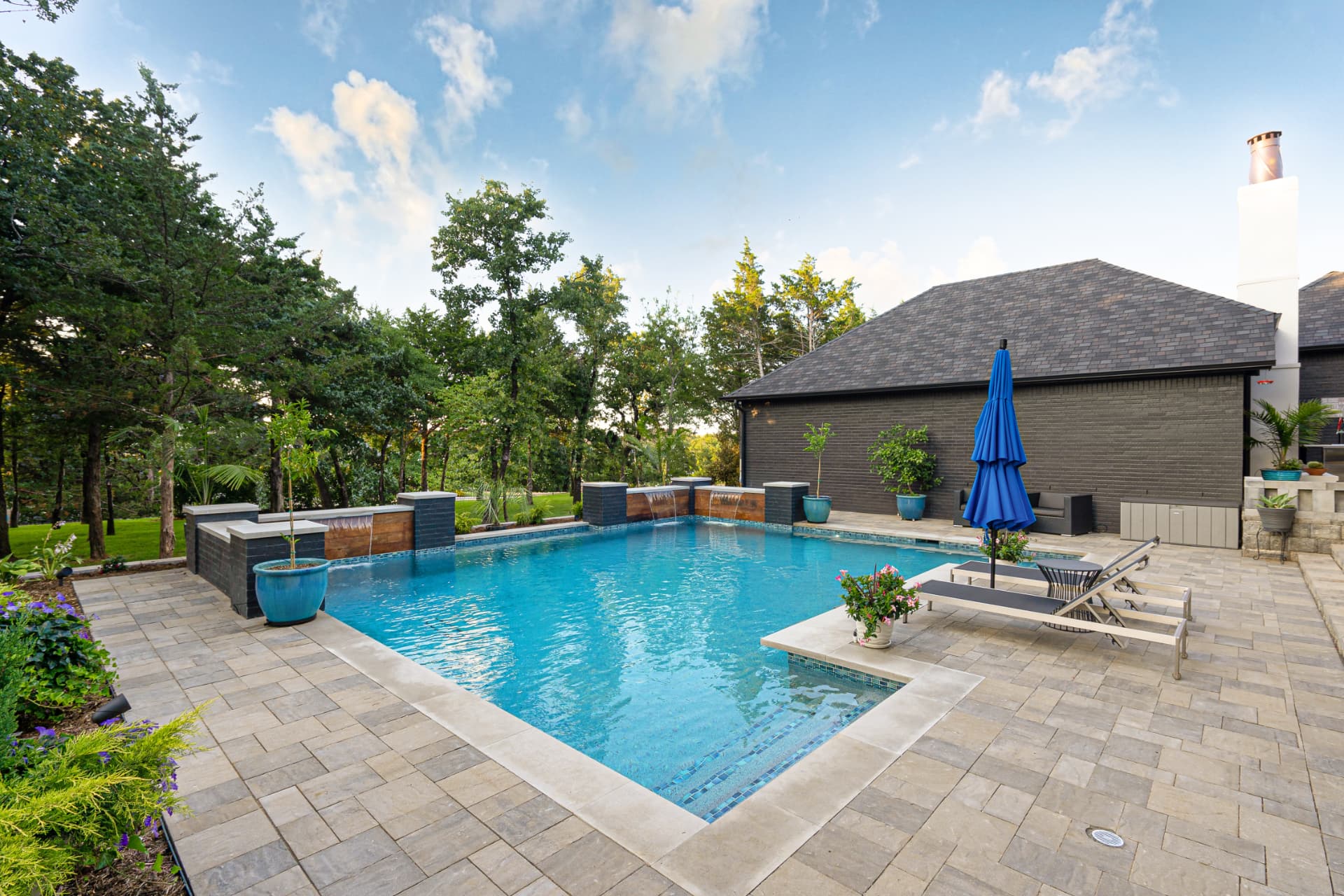 Paver deck and pool with umbrella and lounge seating