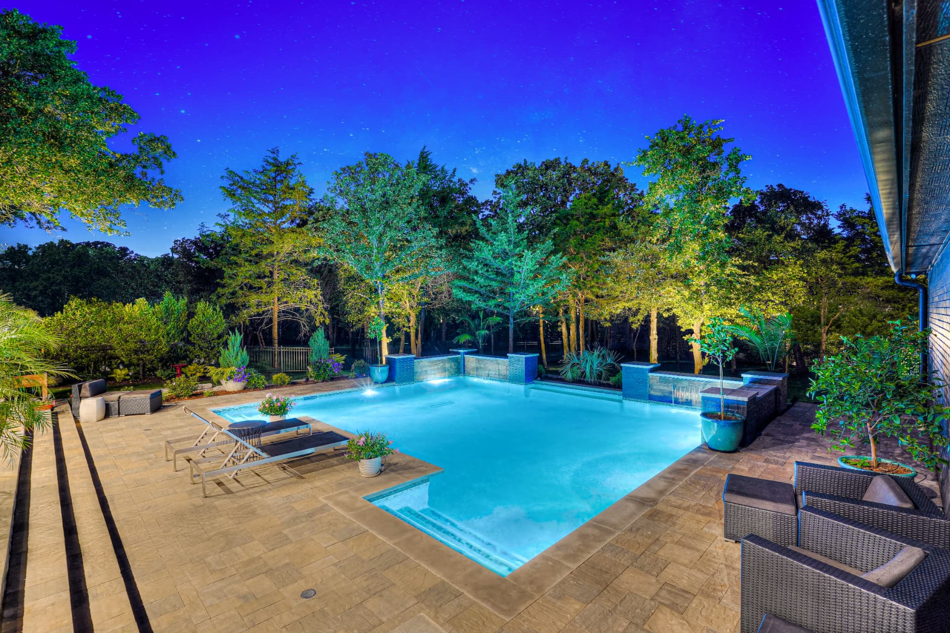 Night view of the pool glowing beneath a deep blue sky