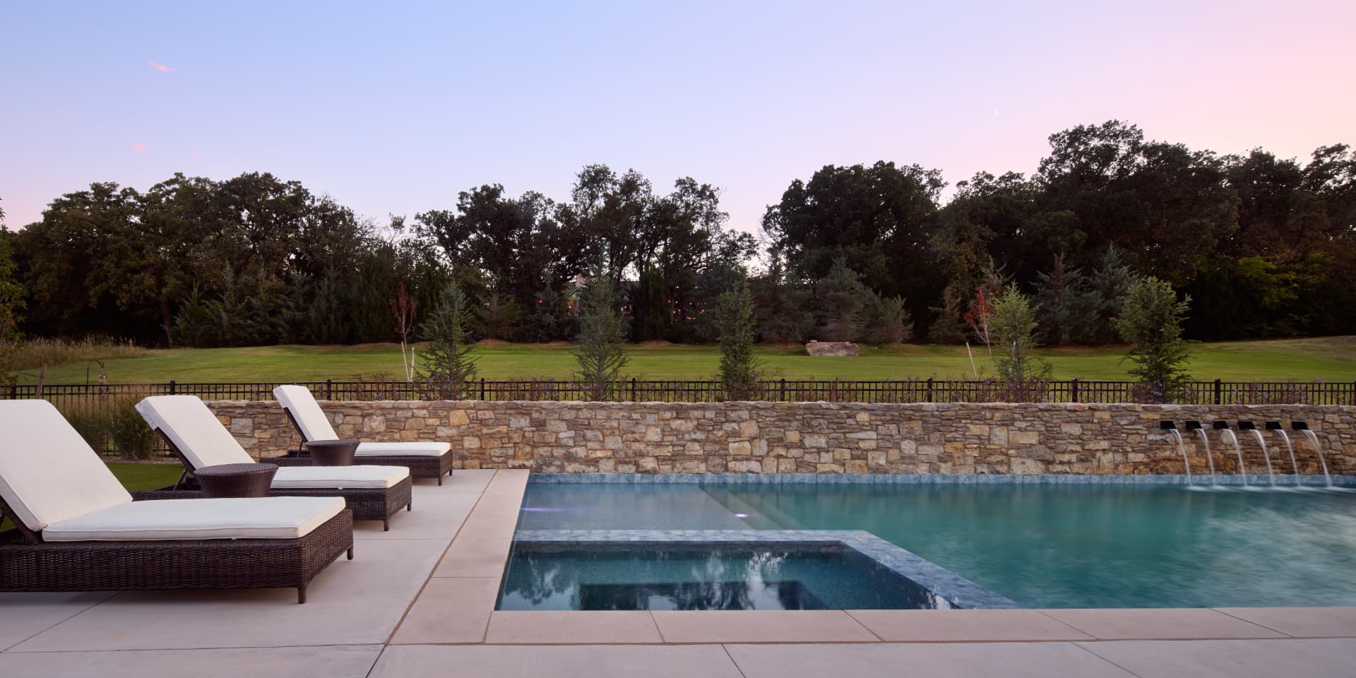 Pool with stone wall sheer descents and lounge chairs