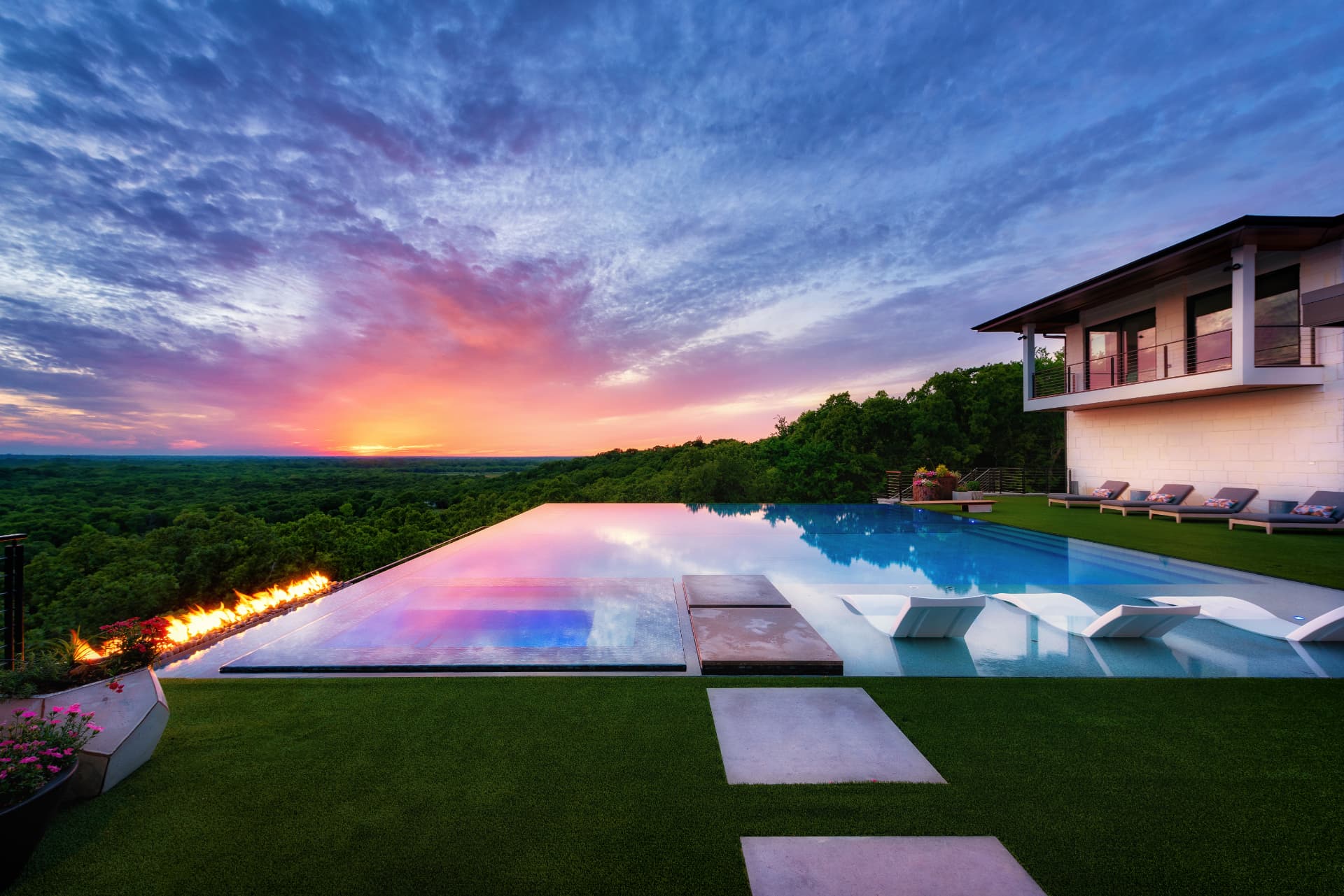 Sunset reflection across the perimeter overflow pool with fire feature